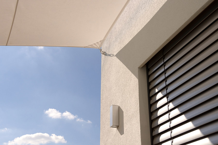 Detail eines modernen Hauses mit Sonnensegel und Raffstoren